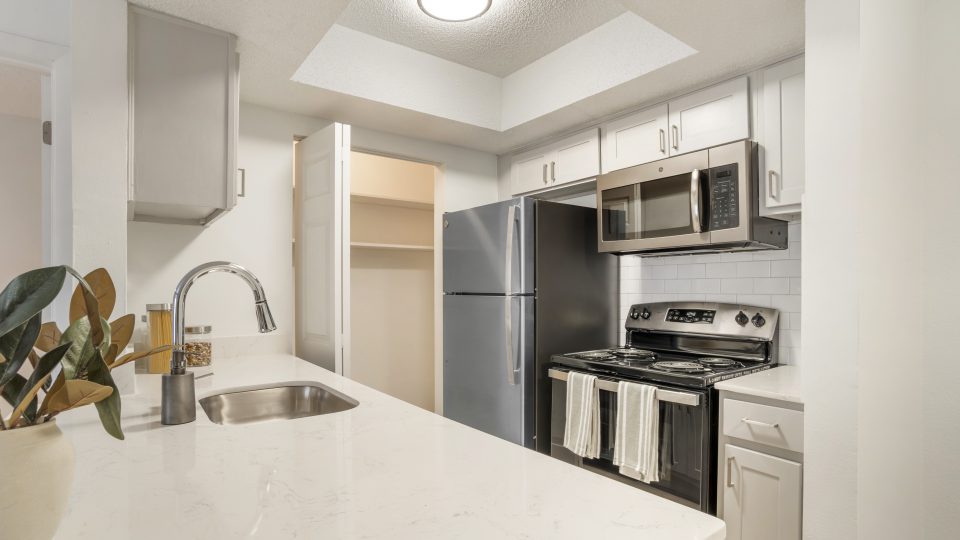 a kitchen with stainless steel appliances and white cabinets at The  Marley